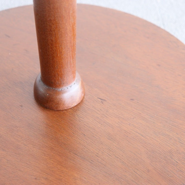 Close-up of vintage British mid-century teak floor lamp base showcasing warm wood grain and smooth rounded leg detail.