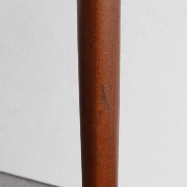 Close-up of a vintage British mid-century teak floor lamp leg showing smooth wood grain and warm brown finish.