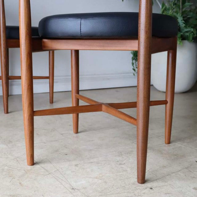 Set of four vintage teak dining chairs by G-plan, showcasing mid-century British design with slender tapered legs and rich.
