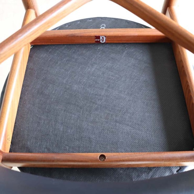 Underside of vintage G-Plan teak dining chair showing mid-century British craftsmanship, wood grain and seat frame details.