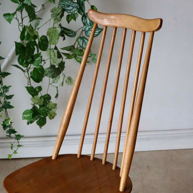Mid-century British Ercol Goldsmith high-back chair in natural teak with slender vertical spindles and gently curved top rail.