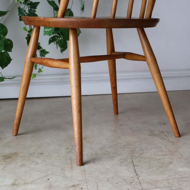 Mid-century British Ercol Goldsmith high-back dining chair in natural teak with visible wood grain and angled legs.