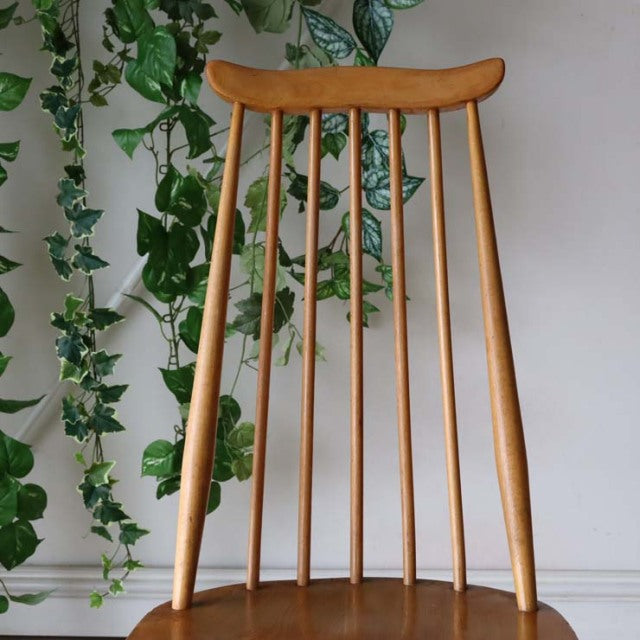 Vintage British Ercol Goldsmith highback chair in natural teak with slender spindled back and tapered legs, mid-century.