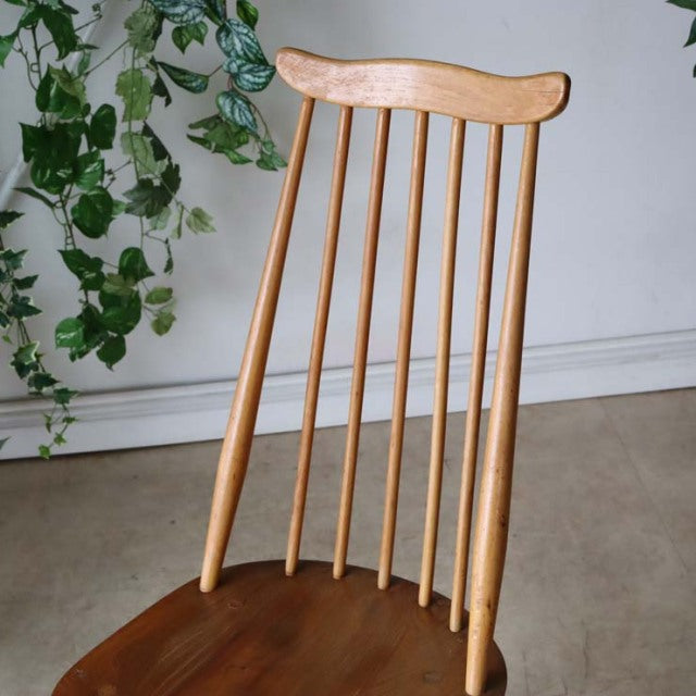 Mid-century British Ercol Goldsmith dining chair in warm teak with slender vertical spindle back and sculpted top rail.