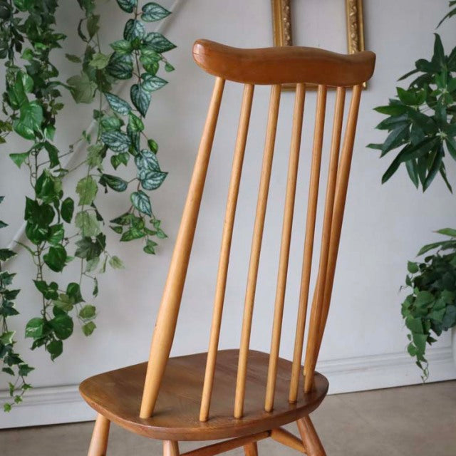 Vintage mid-century British Ercol Goldsmith dining chair in warm teak with slender spindle backrest and sculpted seat.