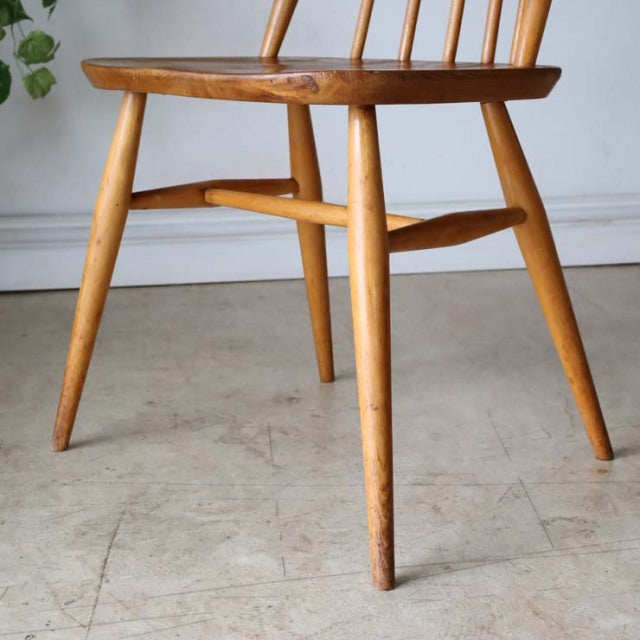 Vintage British mid-century teak dining chair by Ercol with smooth wood grain and angled legs.