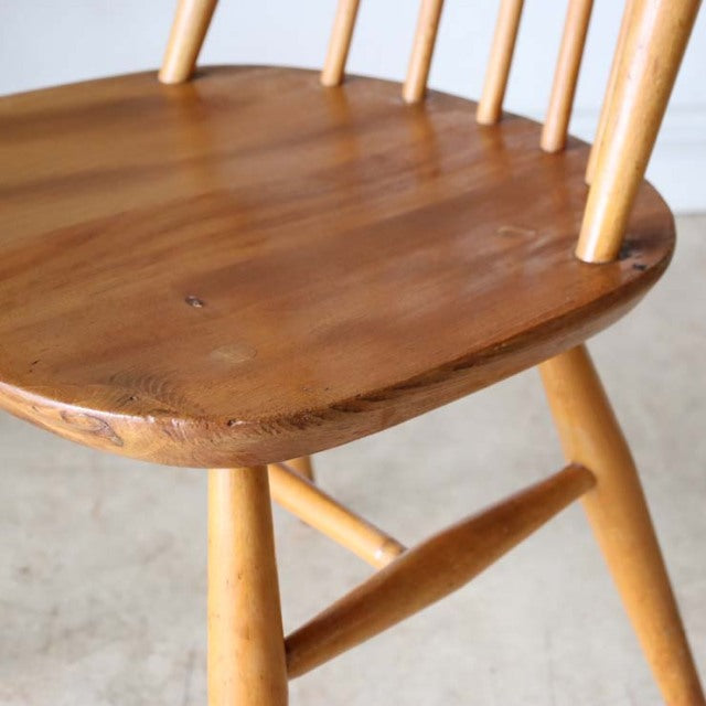 Vintage British Ercol Goldsmith dining chair in teak with smooth rounded seat, spindle backrest, and tapered legs showcasing .