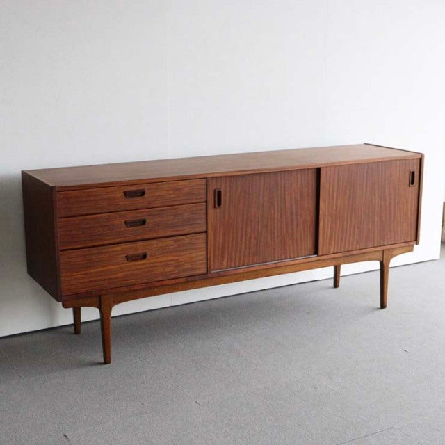 Mid-century British vintage teak sideboard by Nathan with three drawers, sliding doors, and tapered legs.