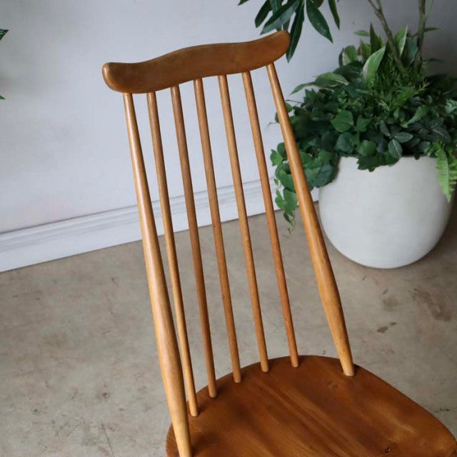 Vintage British mid-century Ercol Goldsmith dining chair in teak with slender spindle back and gently curved top rail.
