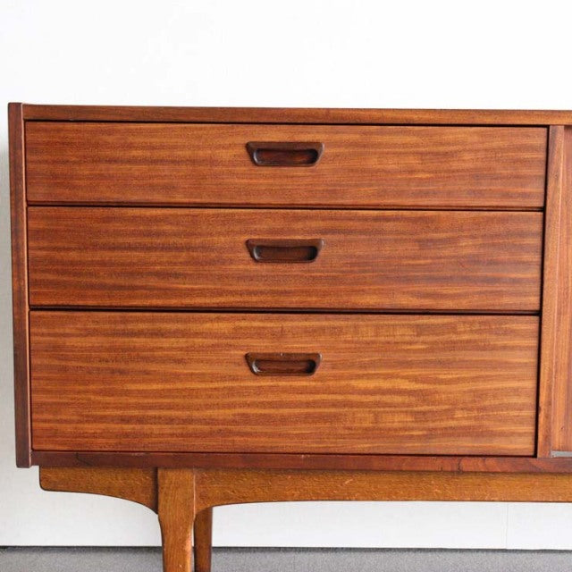 Mid-century British teak sideboard by Nathan featuring rich wood grain, three drawers, and tapered legs.