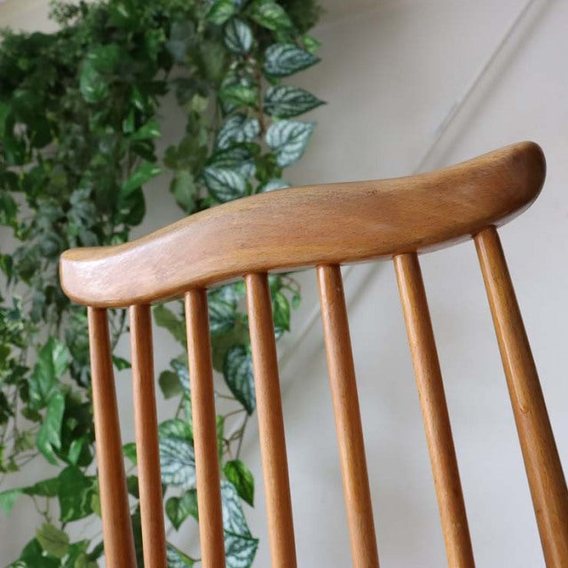 British mid-century vintage Ercol Goldsmith dining chair in teak with curved rounded top rail and slender vertical spindles.