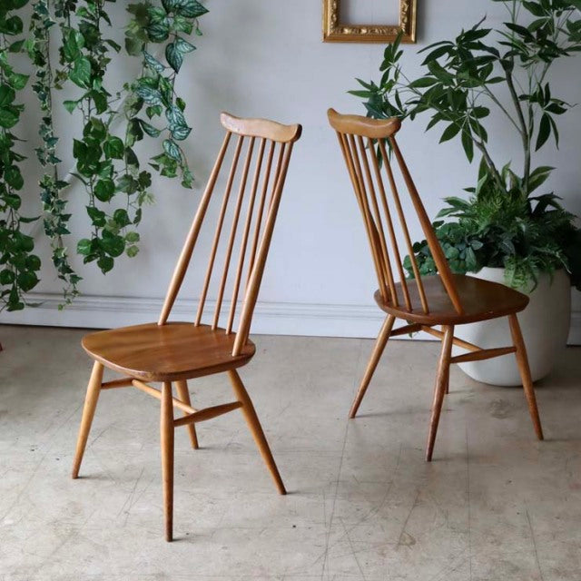 Pair of vintage British mid-century Ercol Goldsmith high-back dining chairs in natural teak with slender spindle backs and.
