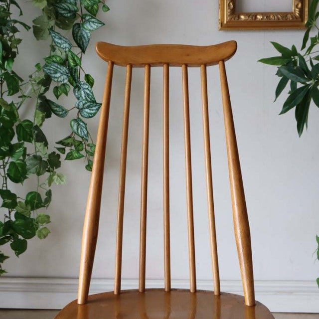 Vintage mid-century British Ercol Goldsmith high-back chair in natural teak with slender vertical spindles and tapered legs.