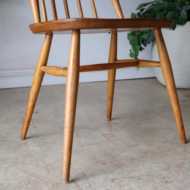 Mid-century British Ercol Goldsmith high-back dining chair in natural teak with visible wood grain and tapered legs.