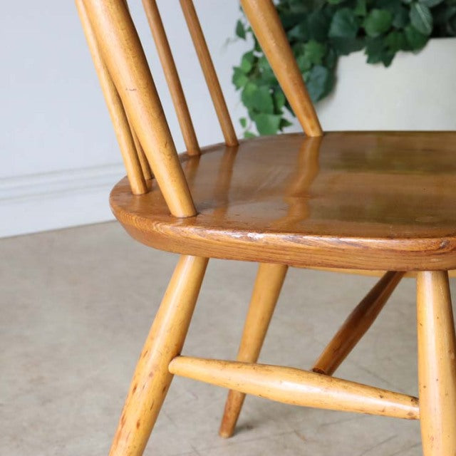 Vintage British Ercol Goldsmith teak dining chair with smooth curved seat and slender spindle back in natural mid-century.