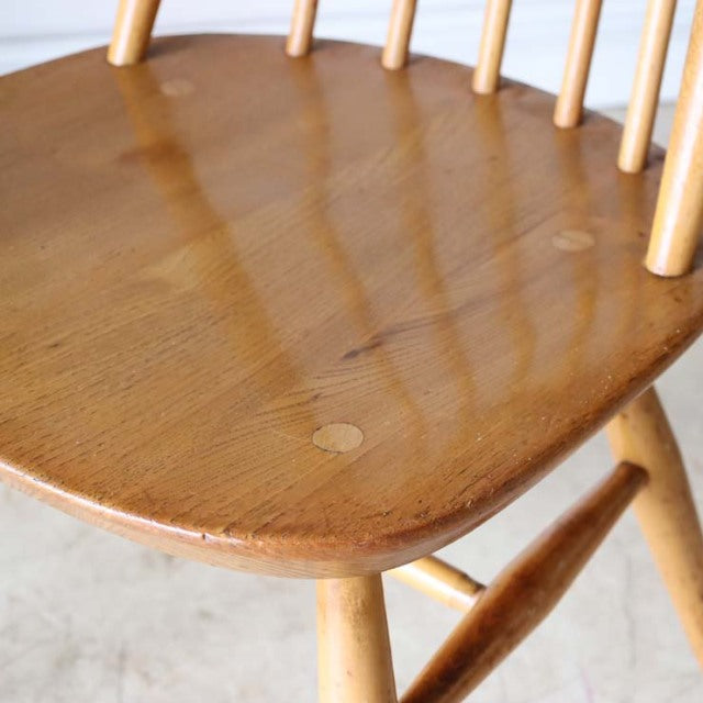 British mid-century ERCOL Goldsmith high-back chair in natural teak with smooth wood grain and slender rounded legs.