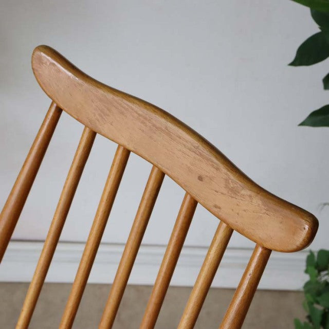 Vintage British Ercol Goldsmith high-back dining chair in natural teak with smooth wood grain and slender spindle legs.