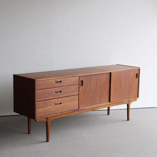 Vintage British teak sideboard by Nathan with mid-century Danish design, smooth wood grain, three drawers, sliding doors,.