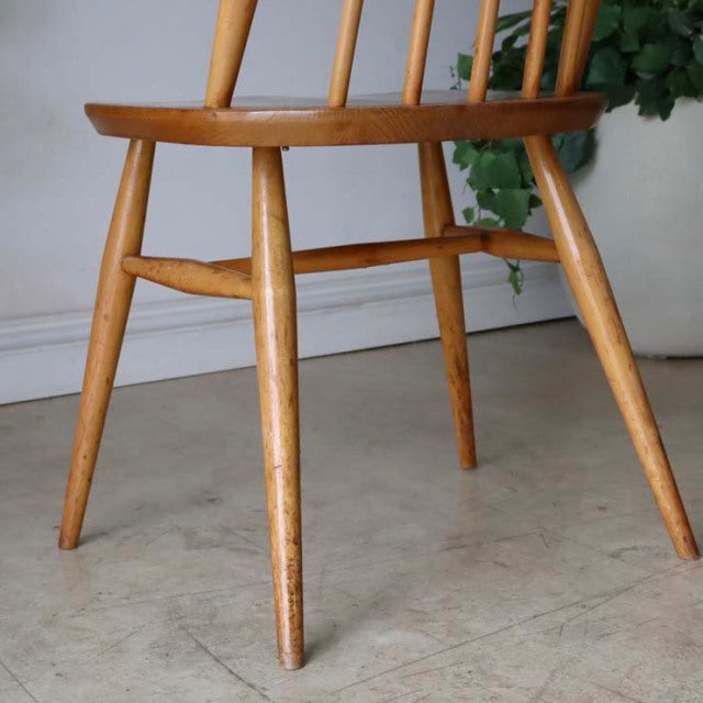 Mid-century British ERCOL Goldsmith chair in natural teak with smooth wood grain and angled legs.