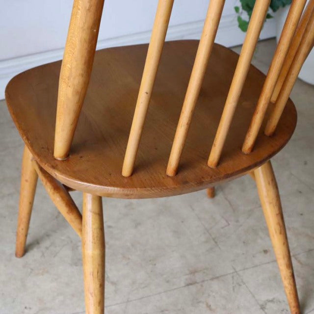 Vintage mid-century Ercol Goldsmith high-back dining chair in natural teak with smooth wood grain and slender tapered legs,.