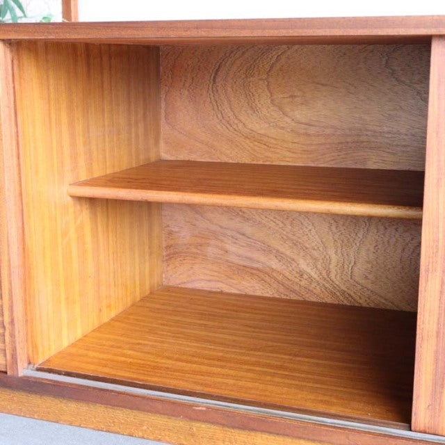Mid-century British teak sideboard interior with wood grain shelves, smooth finish, and clean lines.