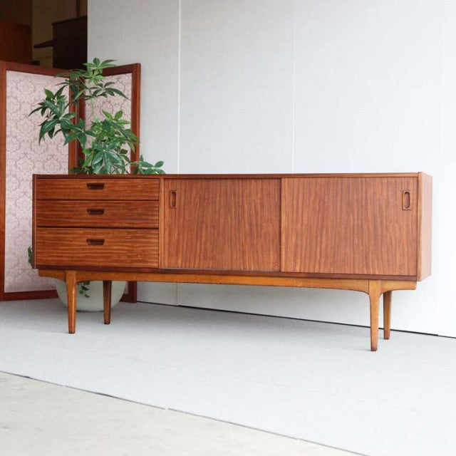 Vintage teak sideboard by British brand Nathan with mid-century Danish design, featuring slatted doors, three drawers, and.