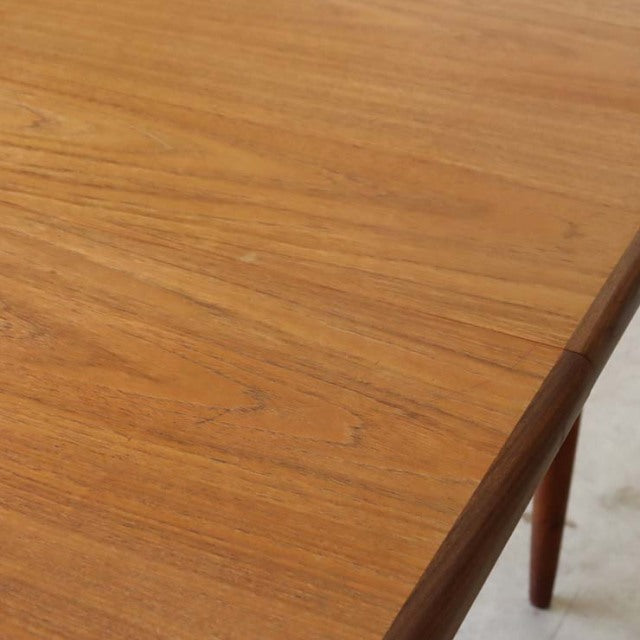 Oval-shaped vintage teak dining table with smooth wood grain and slender tapered legs, British mid-century Danish design by.