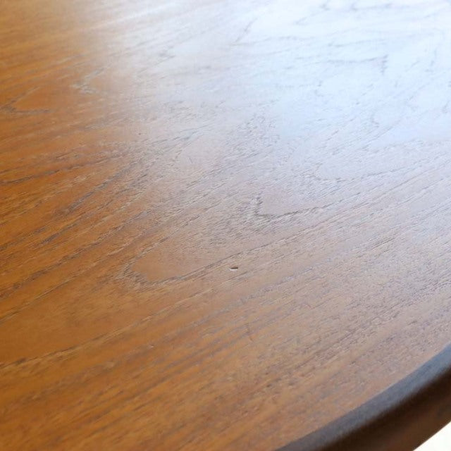 Oval vintage teak dining table top with smooth wood grain and mid-century British craftsmanship details.