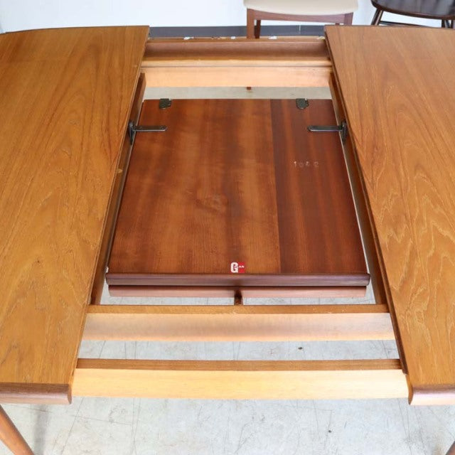 Mid-century British vintage teak oval dining table by G-Plan with extension mechanism and rich wood grain.