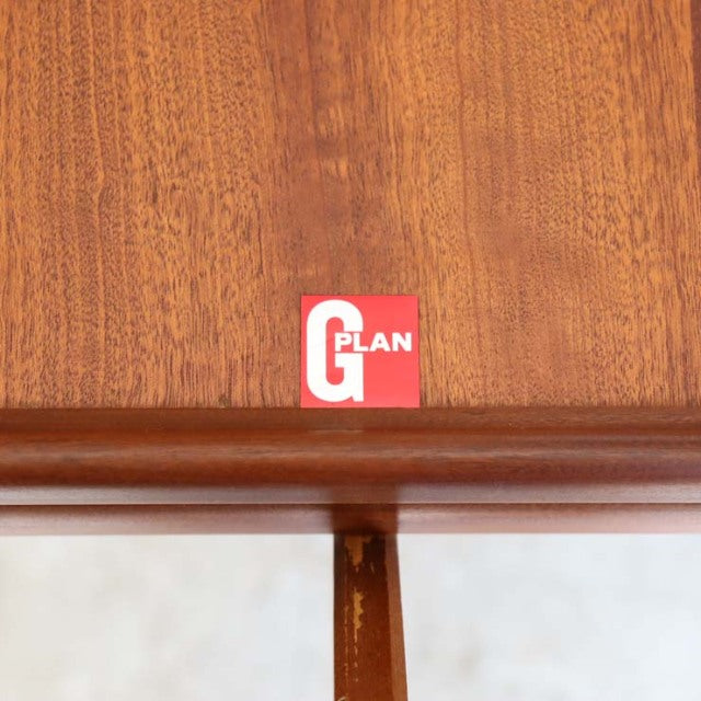 Close-up of vintage teak G-Plan dining table edge showing rich wood grain and mid-century British craftsmanship detail.