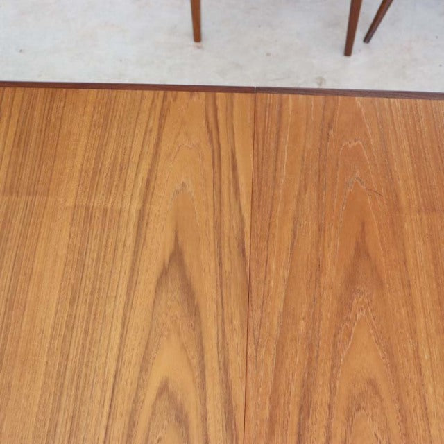 Mid-century British vintage teak dining table top with smooth oval shape and visible wood grain.