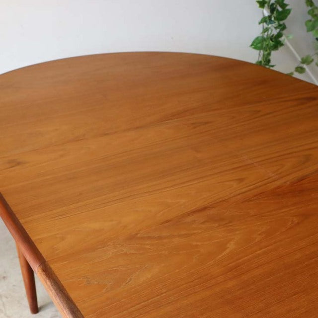 Oval mid-century vintage British G-Plan dining table in warm teak with smooth wood grain and tapered legs.