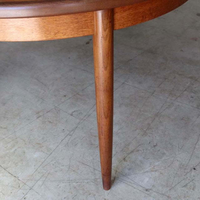 Close-up of vintage teak G-Plan dining table leg showcasing smooth grain and tapered mid-century British design.