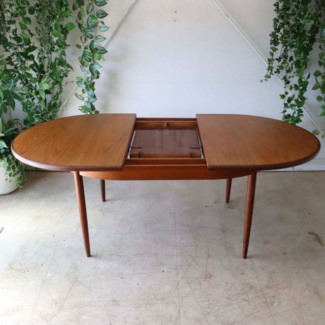 Mid-century British G-Plan teak oval dining table with smooth wood grain and tapered legs, vintage Denmark style.
