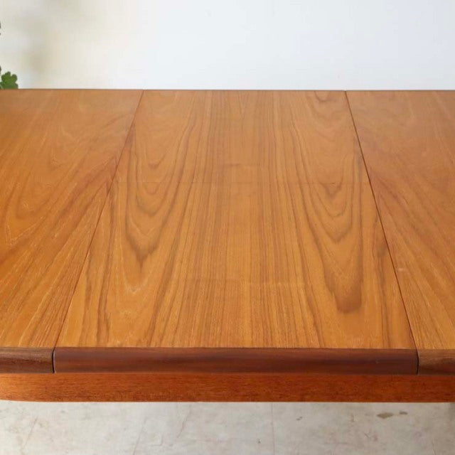 Oval vintage teak dining table top with warm wood grain pattern, mid-century British design.