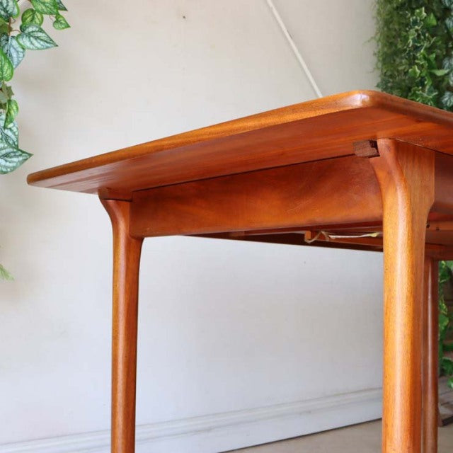 Vintage McIntosh British mid-century teak dining table with smooth wood grain and tapered legs from Denmark.