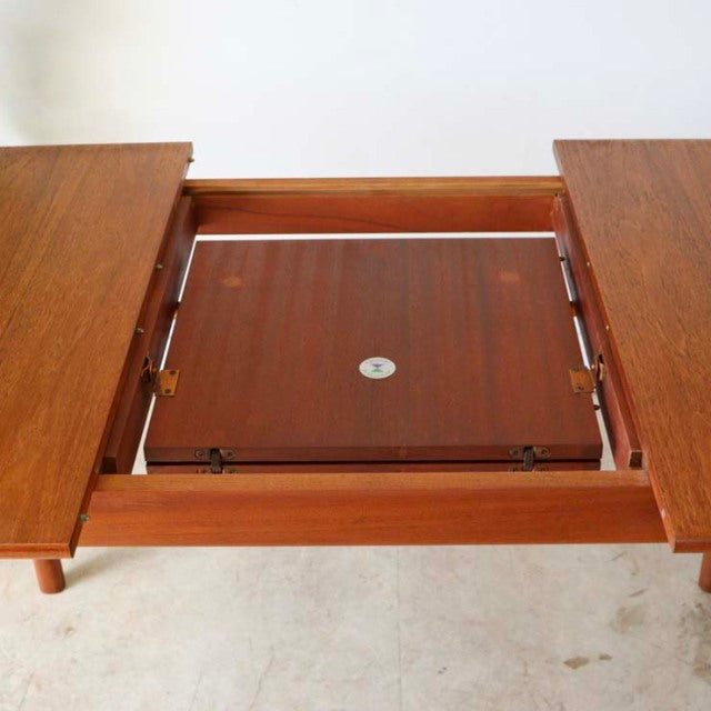 Vintage teak mid-century British dining table by McIntosh with rectangular extending top and visible wood grain.