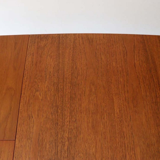 Mid-century British vintage teak dining table top showing smooth wood grain and warm honey tones.