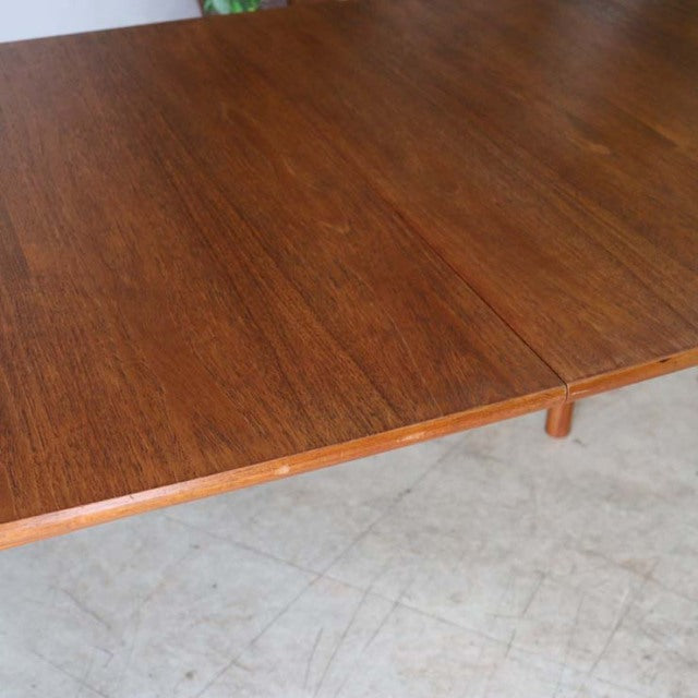 Vintage McIntosh British mid-century teak dining table with rich wood grain and sturdy legs.