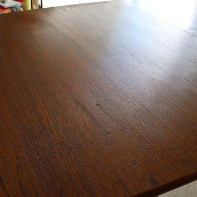 Mid-century British vintage teak dining table with rich wood grain and sturdy tapered legs from Denmark style.