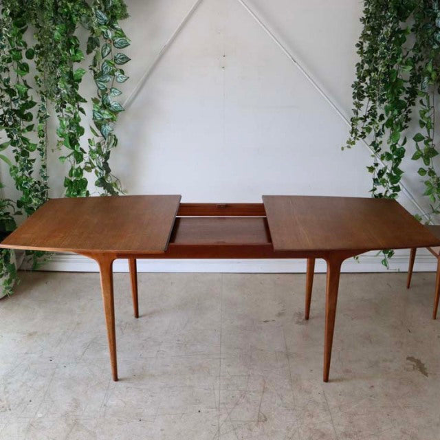 Mid-century British vintage teak dining table by McIntosh with rectangular top, gracefully tapered legs, and extension.