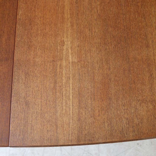 Vintage British mid-century teak dining table with smooth grain and warm honey finish.