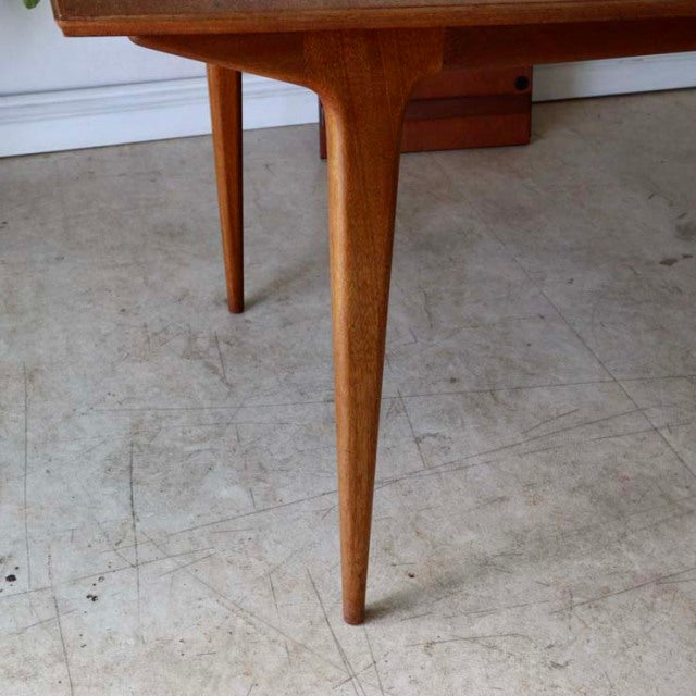 Mid-century British vintage teak dining table leg with smooth wood grain and tapered design.