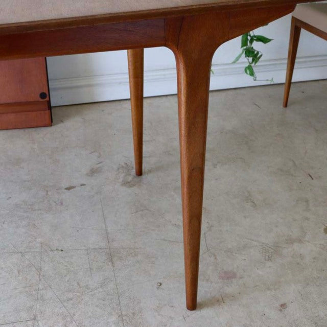 Mid-century British vintage McIntosh dining table leg in rich teak with smooth tapered design and visible wood grain.