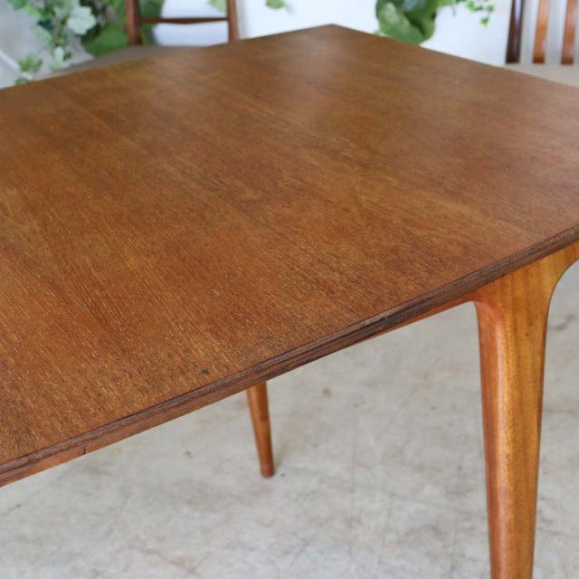 Vintage mid-century British teak dining table with rich wood grain and tapered legs from McIntosh.