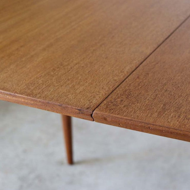 Vintage teak McIntosh dining table corner showing rich wood grain and mid-century British craftsmanship.
