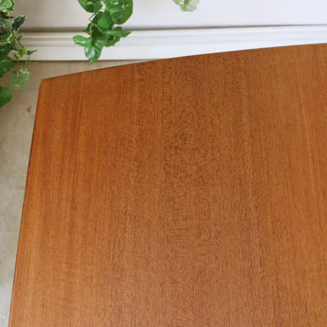 Vintage teak McIntosh dining table corner showing smooth wood grain and warm mid-century British design.