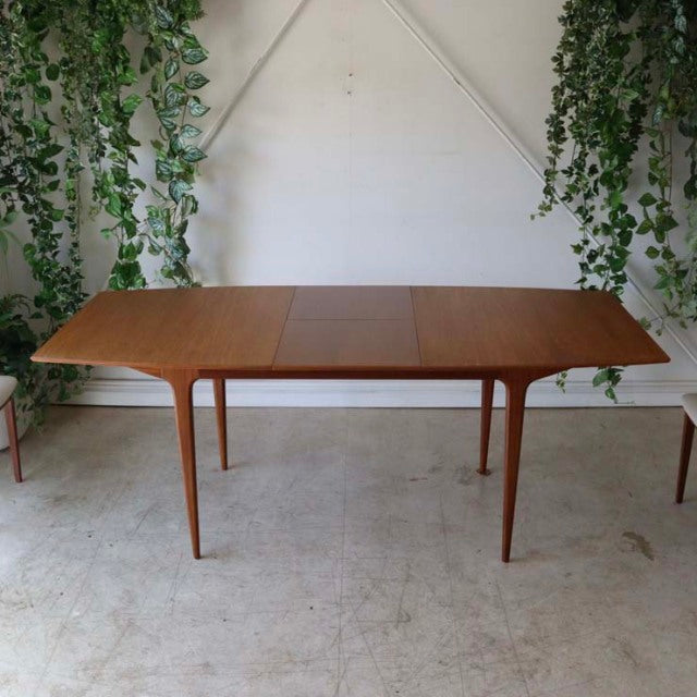 Mid-century British vintage teak dining table by McIntosh, rectangular with rounded edges and tapered legs, smooth wood.