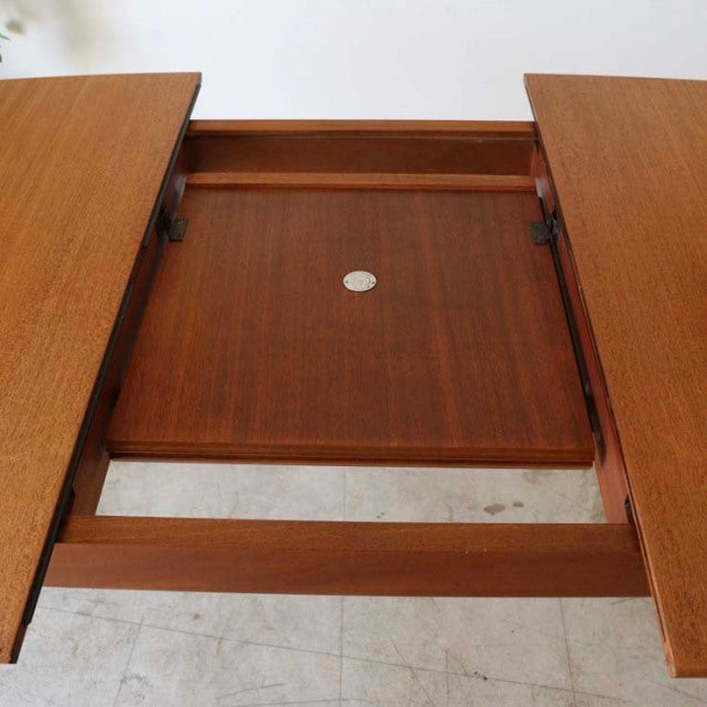 Mid-century British vintage teak dining table by McIntosh with extendable leaves and visible wood grain.