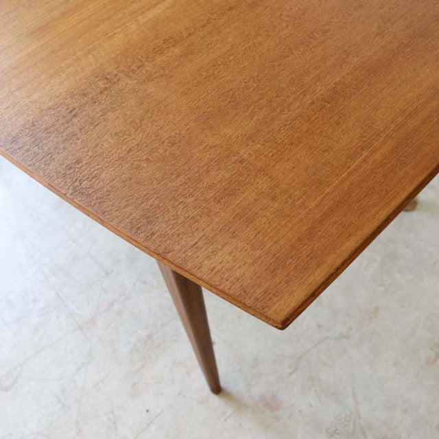Vintage British mid-century teak dining table with smooth wood grain, tapered legs, and simple rectangular design from.